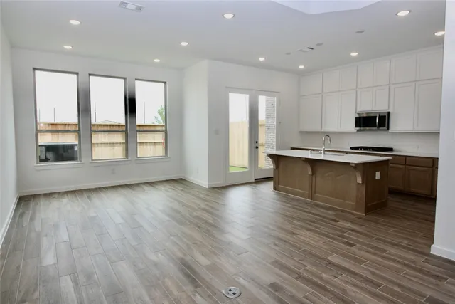 a kitchen with stainless steel appliances granite countertop a stove a sink and a microwave