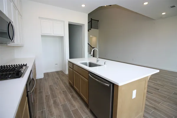 a kitchen with a sink a microwave and cabinets