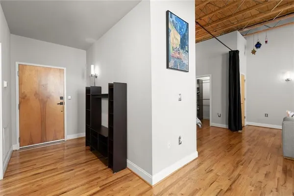 a view of an empty room with wooden floor and a cabinet