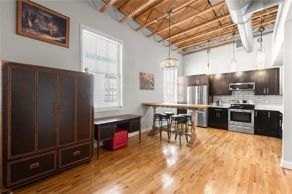 a kitchen with stainless steel appliances wooden floors and wooden cabinets