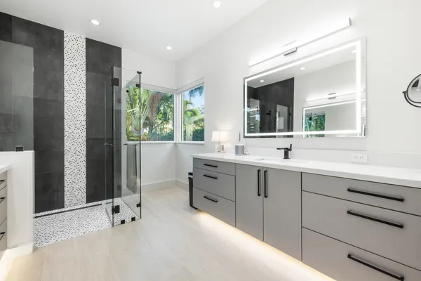 a spacious bathroom with double vanity and a large mirror