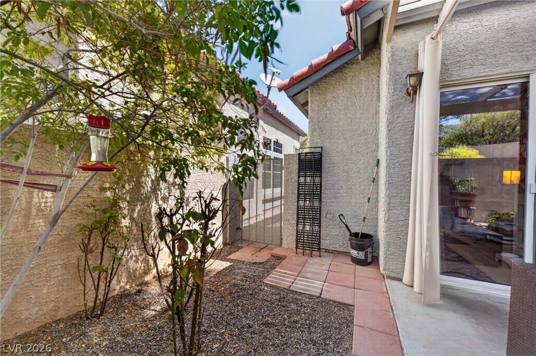 2247 Ramsgate Drive, Unit 2247 Henderson, NV 89074 - Photo 35 of 50 A tranquil side yard features a paved patio, gravel landscaping, and lush greenery.