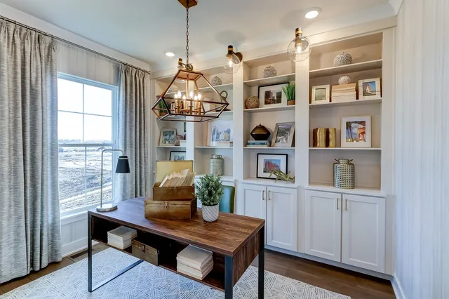 a view of a workspace with furniture and a window