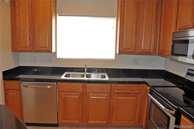 a kitchen with granite countertop cabinets stainless steel appliances and a sink