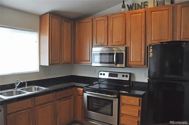 a kitchen with stainless steel appliances granite countertop a refrigerator stove and sink