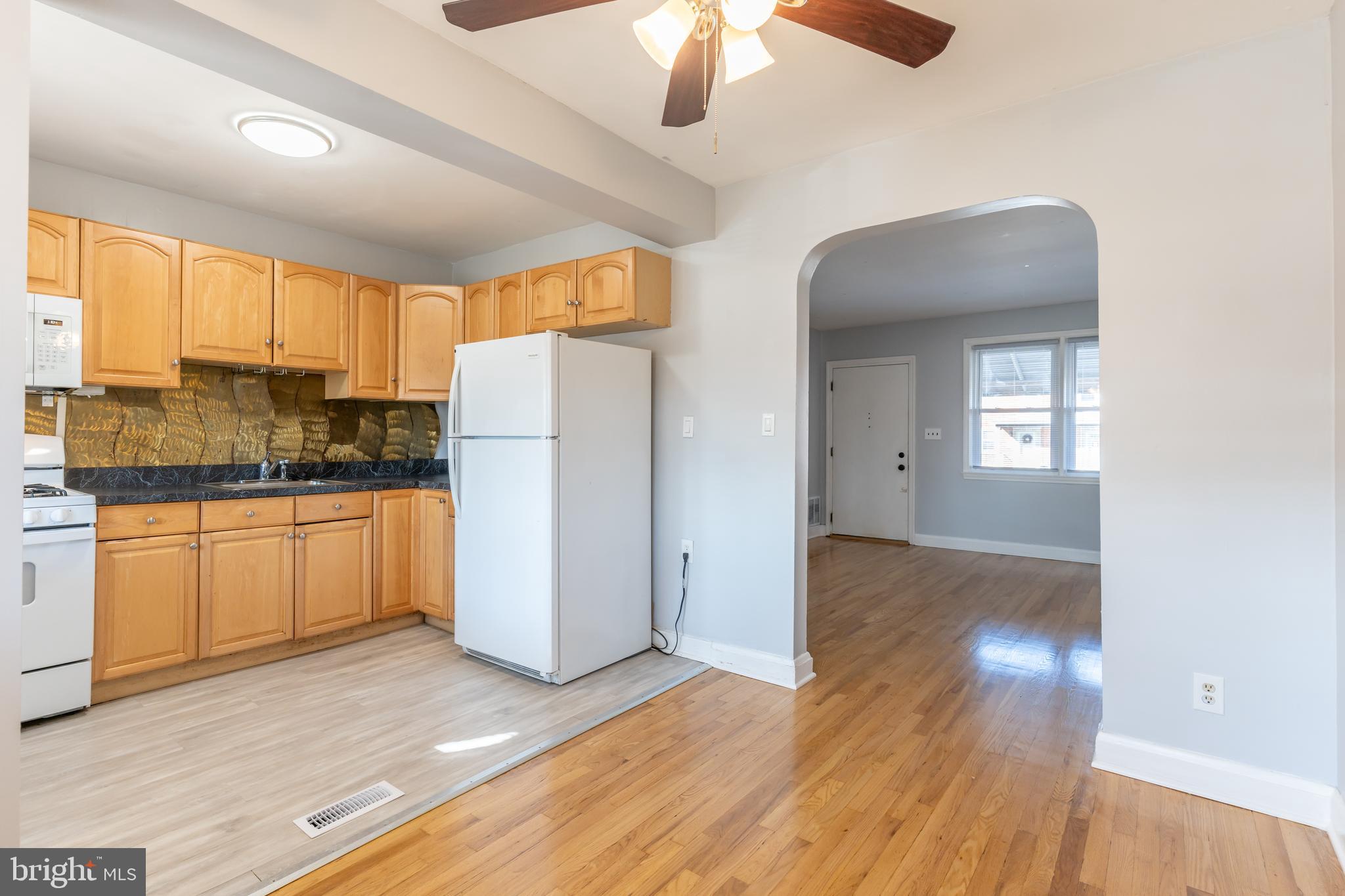 577 Welbrook Road Baltimore, MD 21221 - Photo 11 of 31 a kitchen with a refrigerator a stove cabinets and wooden floor