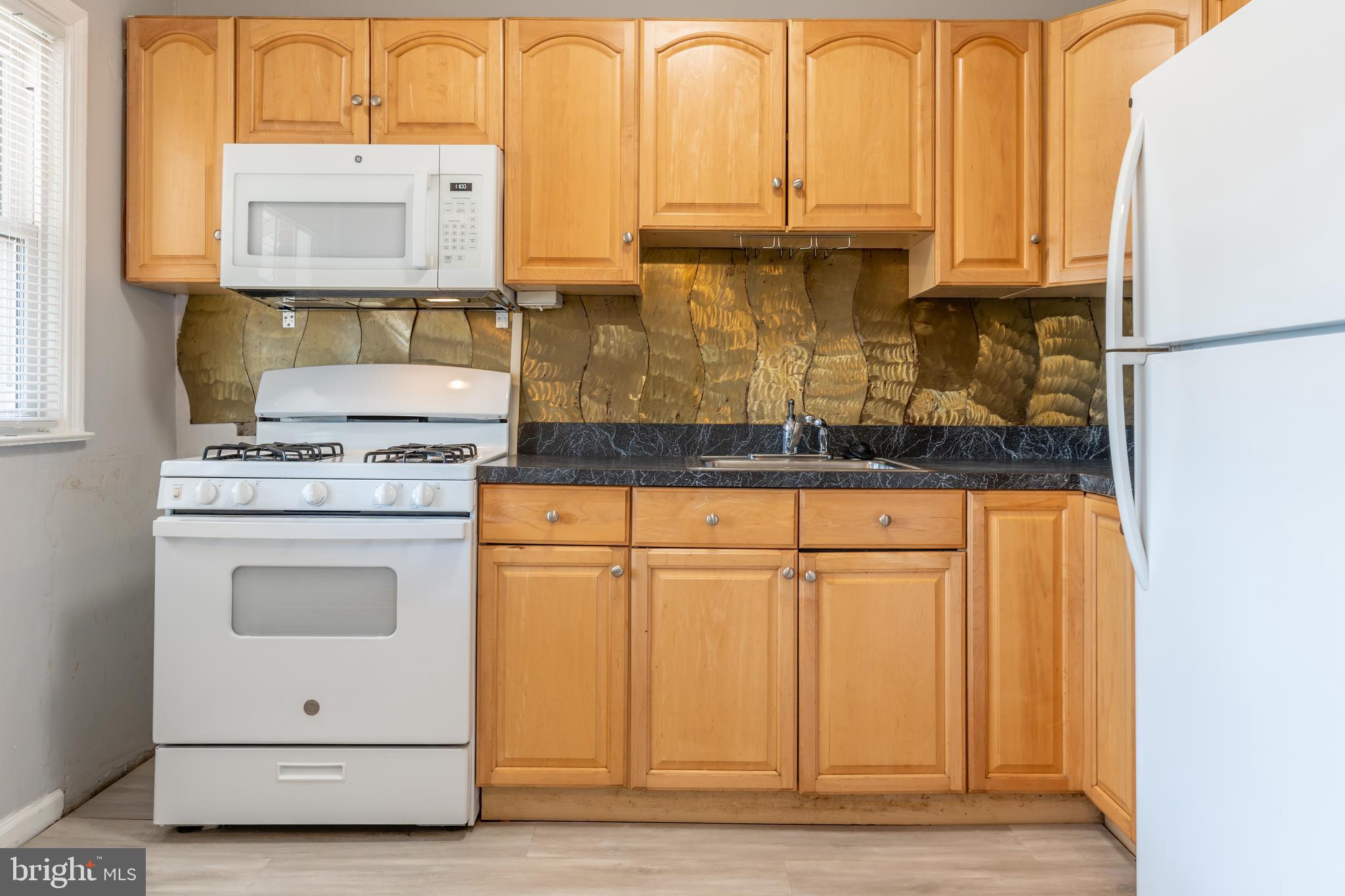577 Welbrook Road Baltimore, MD 21221 - Photo 14 of 31 a kitchen with granite countertop white cabinets and white appliances