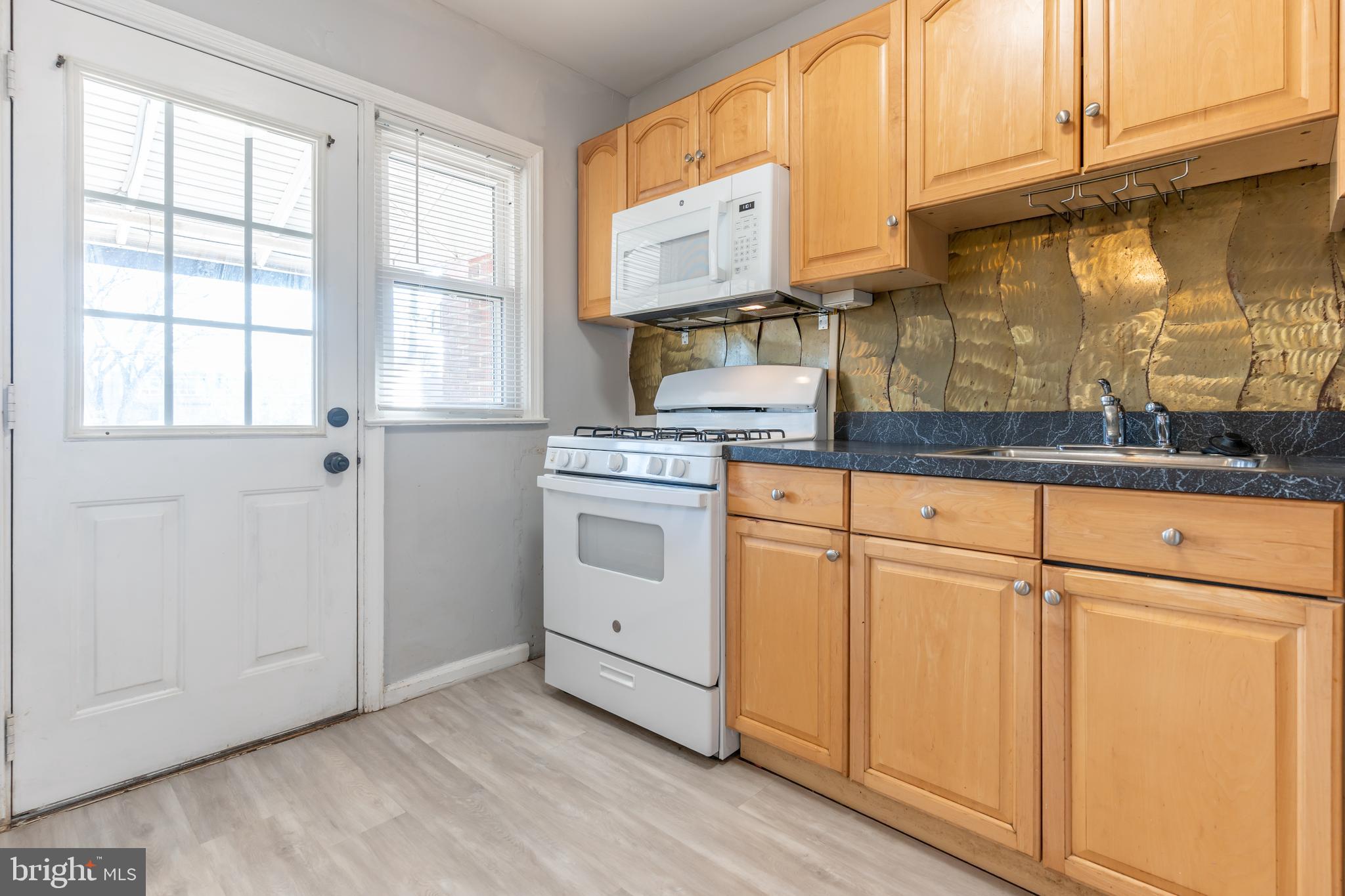 577 Welbrook Road Baltimore, MD 21221 - Photo 10 of 31 a kitchen with granite countertop white cabinets and white appliances