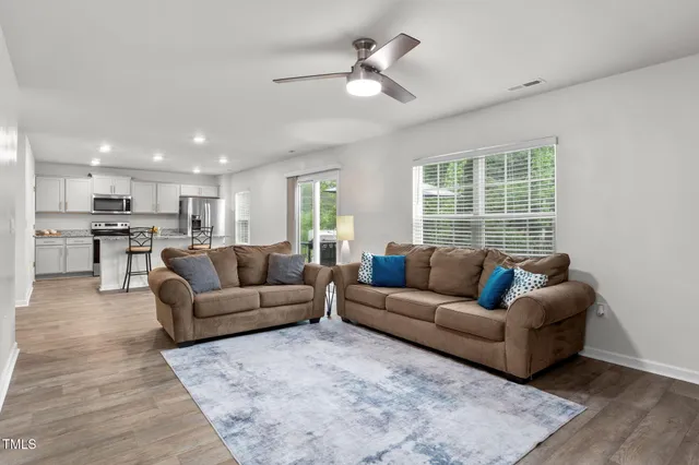 a living room with furniture and a view of kitchen