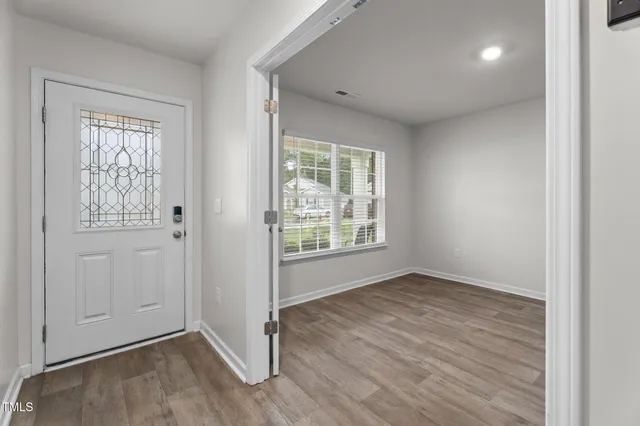 a kitchen with kitchen island granite countertop a stove a sink a microwave a dining table and chairs