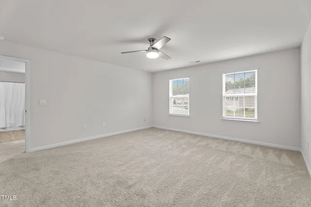 an empty room with fan and a ceiling fan
