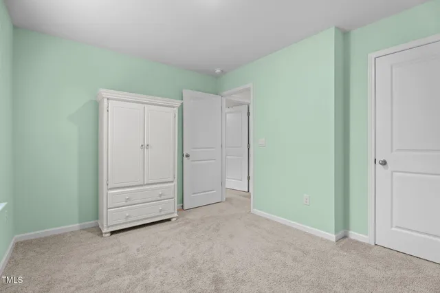 a bedroom with a bed a couch and a flat tv screen on the dresser