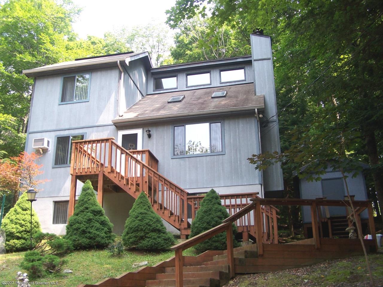 a front view of a house with yard and deck