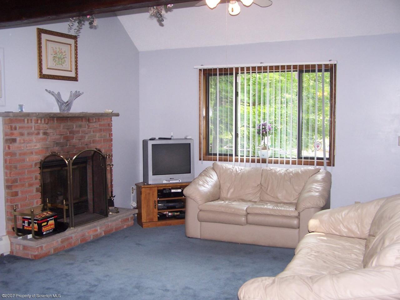 3300 Northgate Road Lake Ariel, PA 18436 - Photo 2 of 11 a living room with furniture a flat screen tv and a fireplace