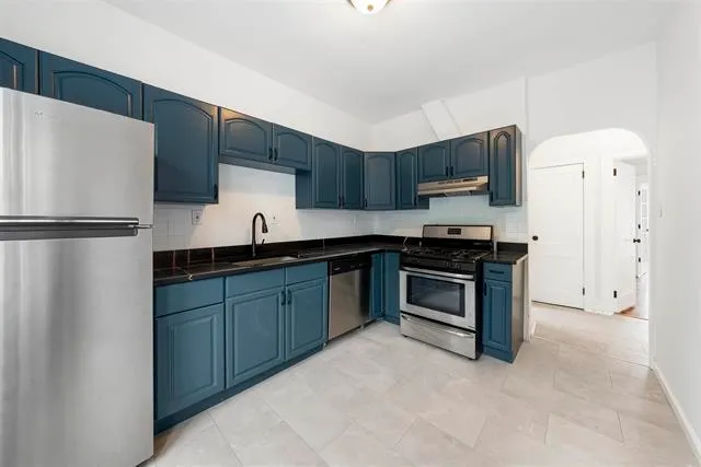 a kitchen with stainless steel appliances a refrigerator sink and microwave