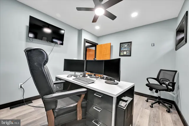 a view of a workspace with furniture and flat screen tv