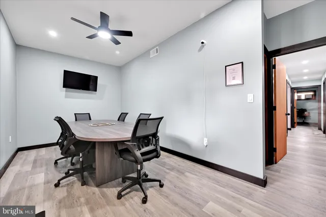 a view of a workspace with furniture and wooden floor