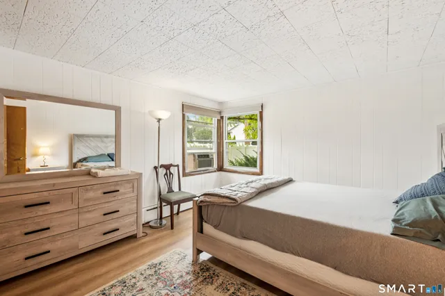 a bedroom with a bed and a mirror on dresser