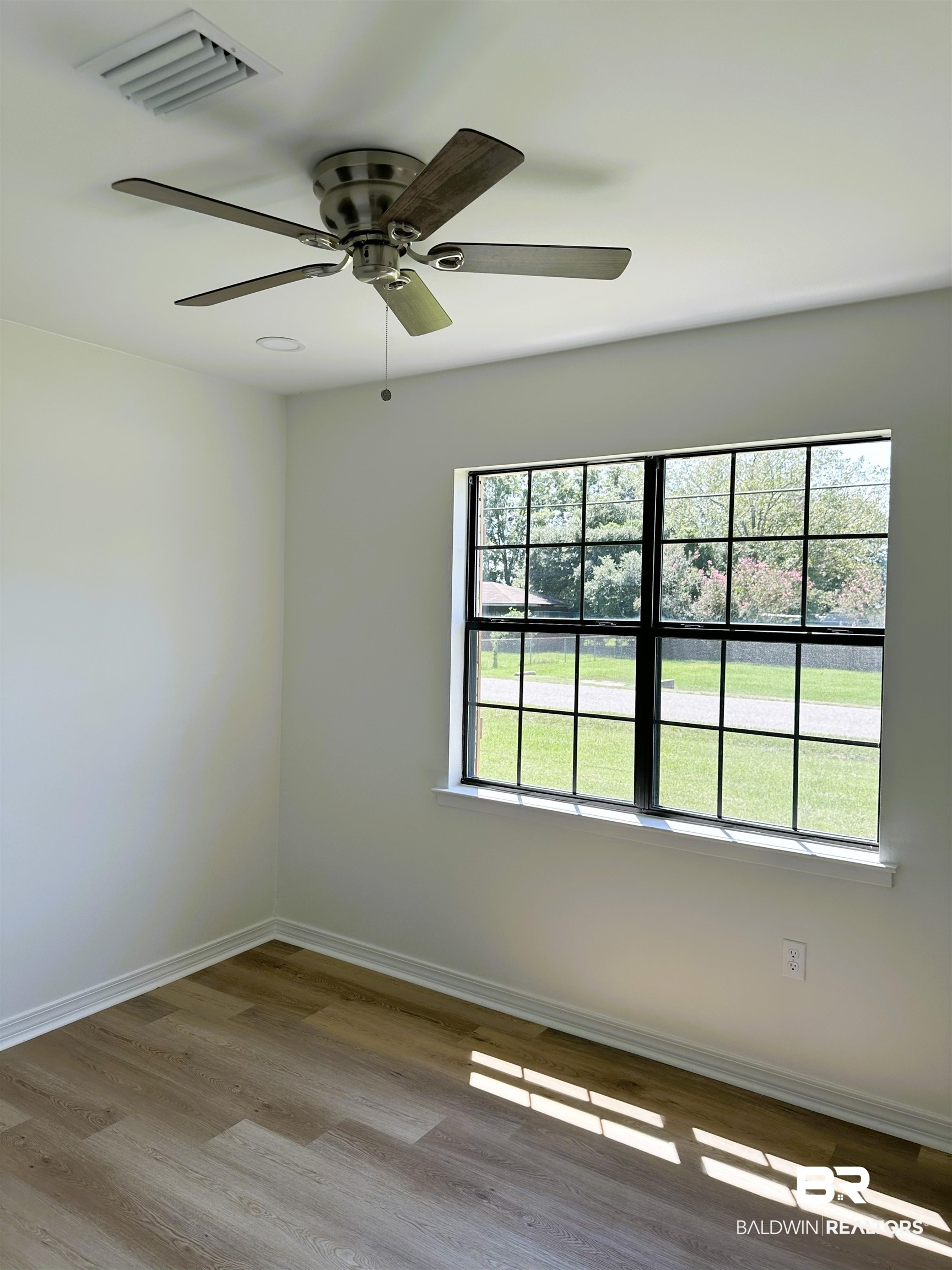 701 McRae Street Atmore, AL 36502 - Photo 8 of 11 Unfurnished room featuring light wood-style floors and a ceiling fan