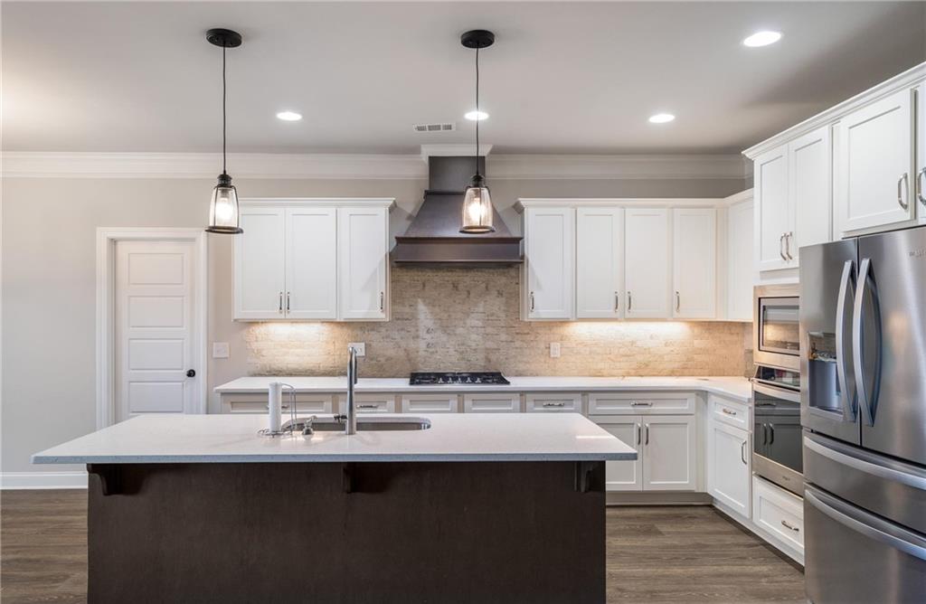 712 Fleeting Way Monroe, GA 30655 - Photo 4 of 29 a kitchen with stainless steel appliances a sink stove and refrigerator