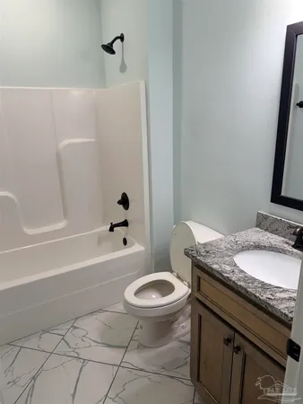 a bathroom with a granite countertop toilet a sink and bathtub