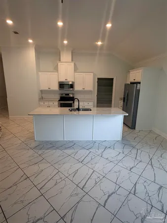 a kitchen with stainless steel appliances a refrigerator and a stove top oven