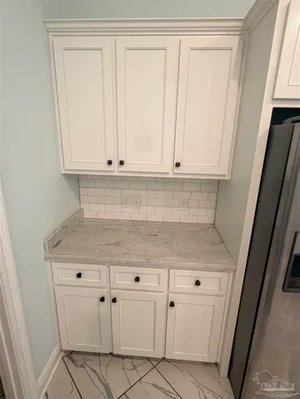 a kitchen with white cabinets and white appliances