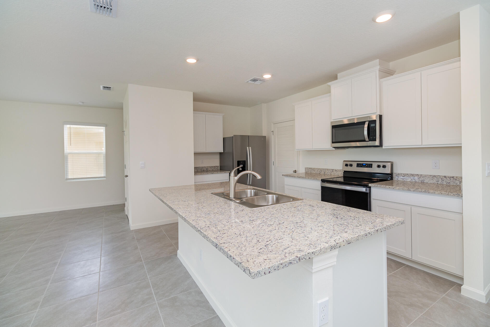 569 Seaspray Drive Fort Pierce, FL 34945 - Photo 6 of 28 a kitchen with granite countertop stainless steel appliances a stove sink microwave and cabinets