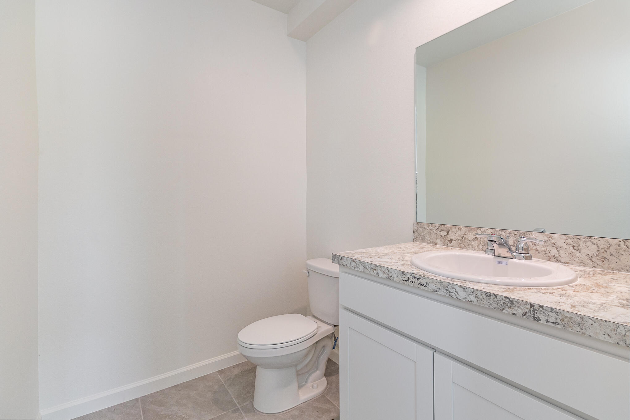 569 Seaspray Drive Fort Pierce, FL 34945 - Photo 8 of 28 a bathroom with a granite countertop toilet and sink