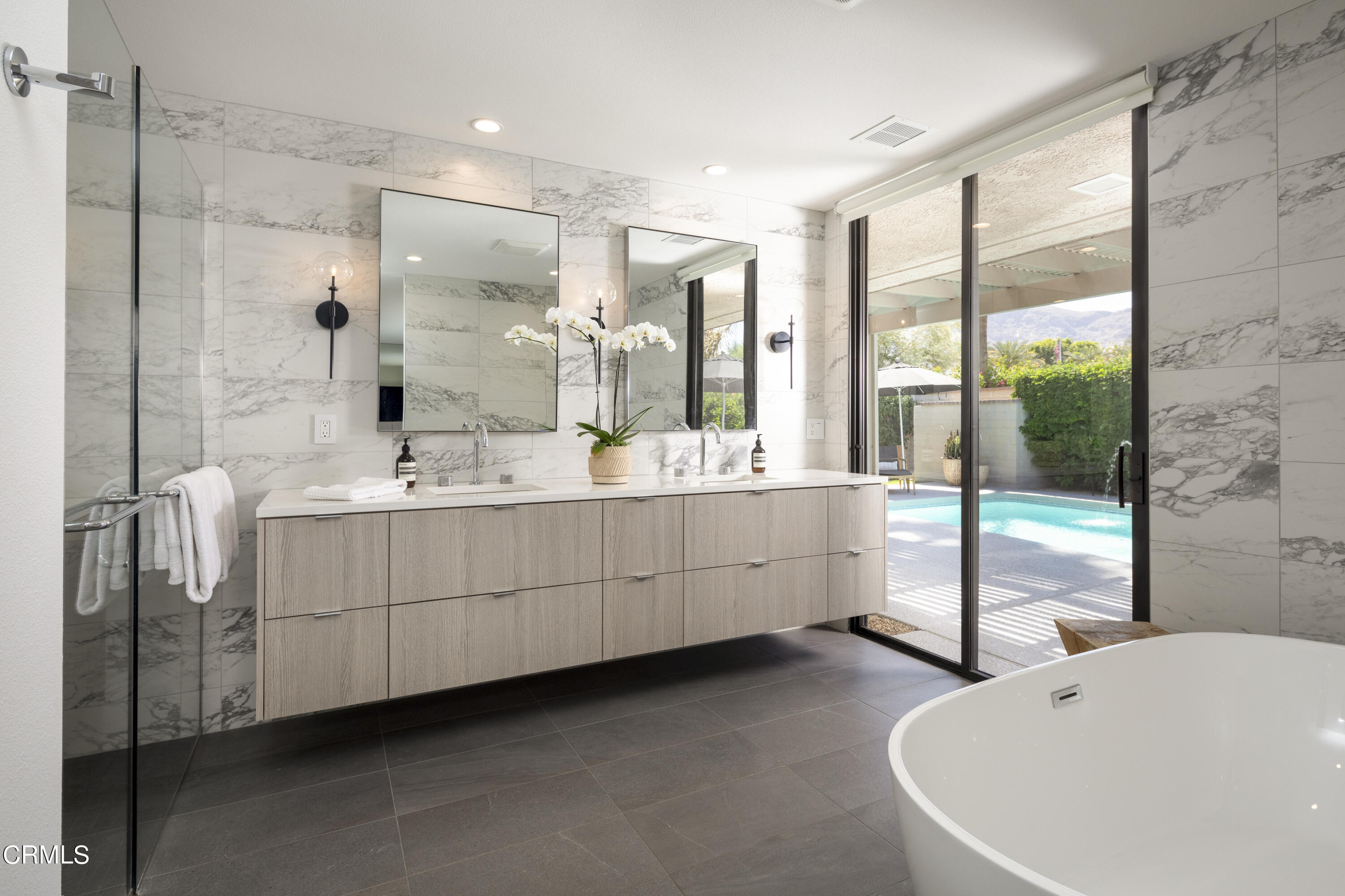 56 Princeton Drive Rancho Mirage, CA 92270 - Photo 17 of 35 a bathroom with a double vanity sink a large mirror and bathtub
