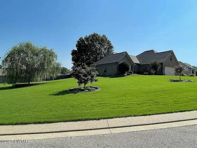 a view of a garden with a house in the background