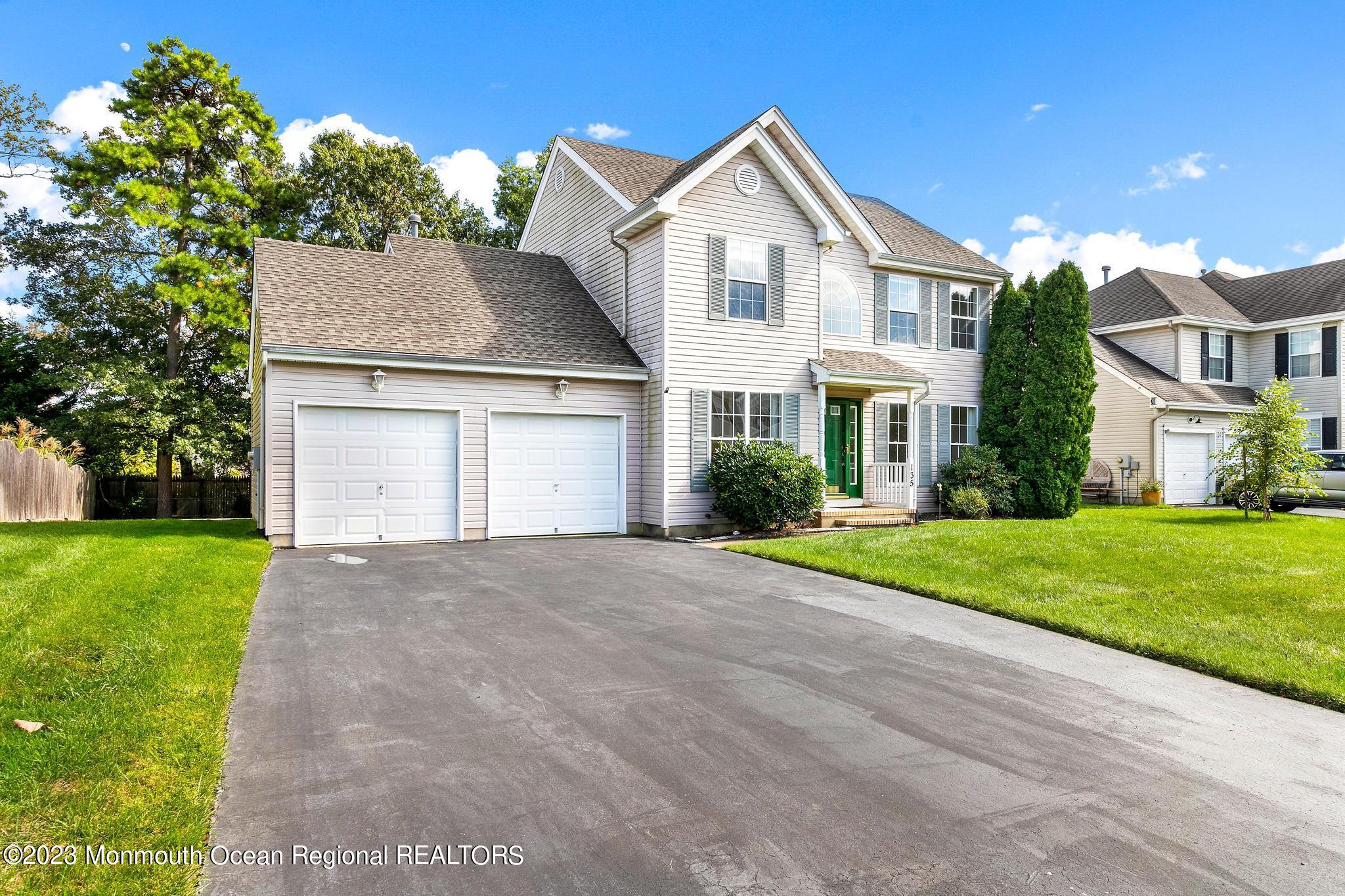 135 Barracuda Road Manahawkin, NJ 08050 - Photo 3 of 47 a front view of a house with a yard and garage