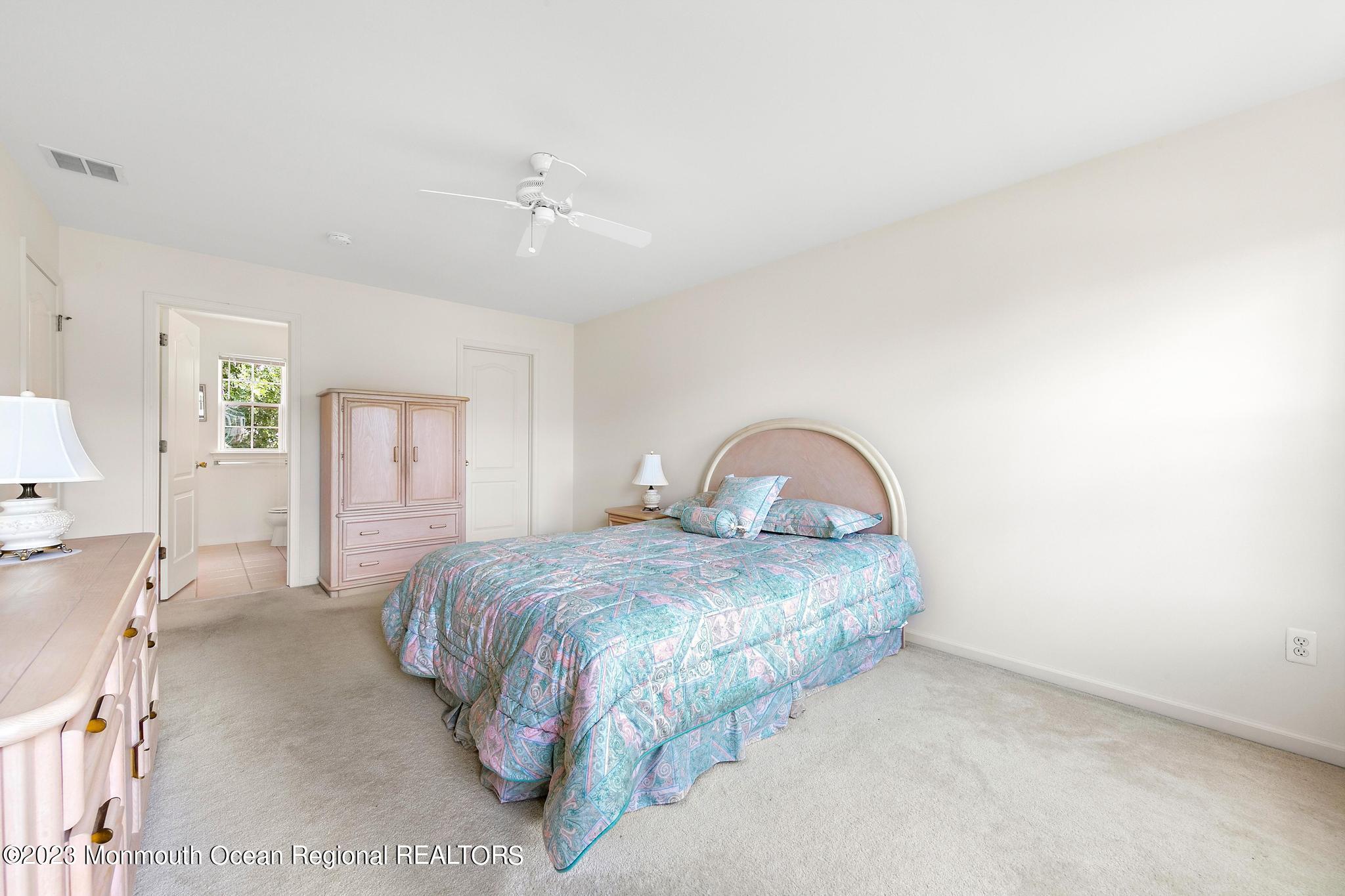 135 Barracuda Road Manahawkin, NJ 08050 - Photo 34 of 47 a bedroom with a bed and a chandelier