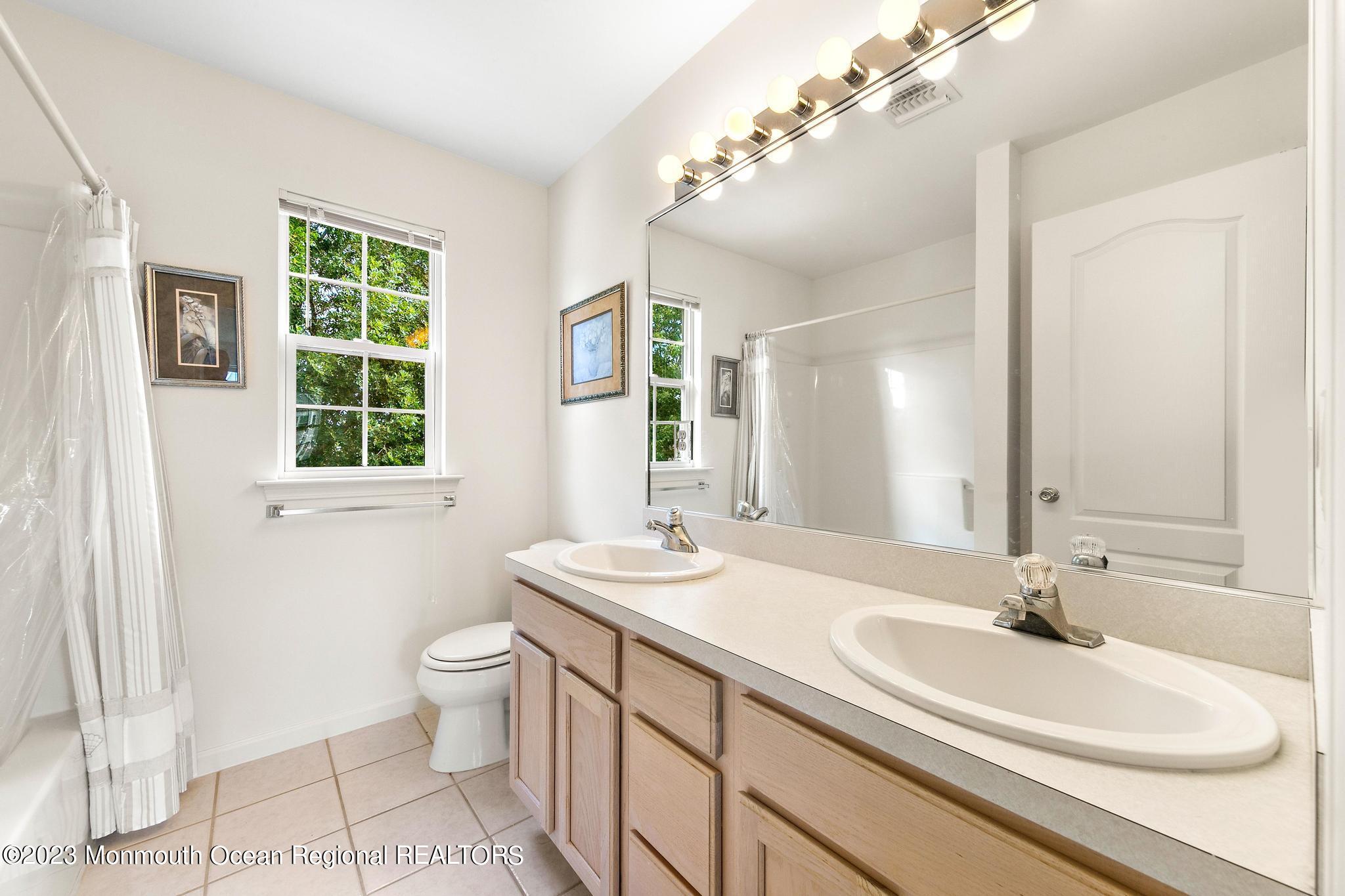 135 Barracuda Road Manahawkin, NJ 08050 - Photo 35 of 47 a bathroom with a sink a toilet and a mirror