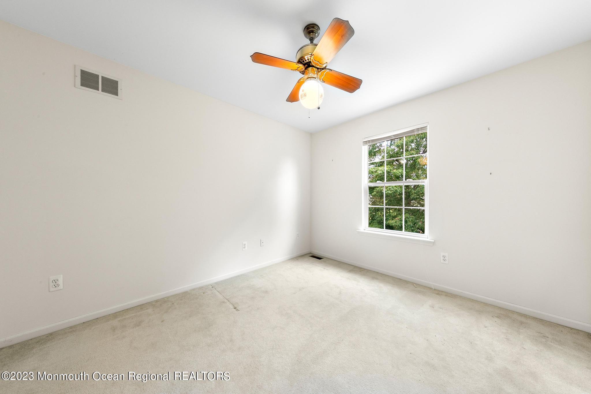 135 Barracuda Road Manahawkin, NJ 08050 - Photo 38 of 47 an empty room with ceiling fan and window