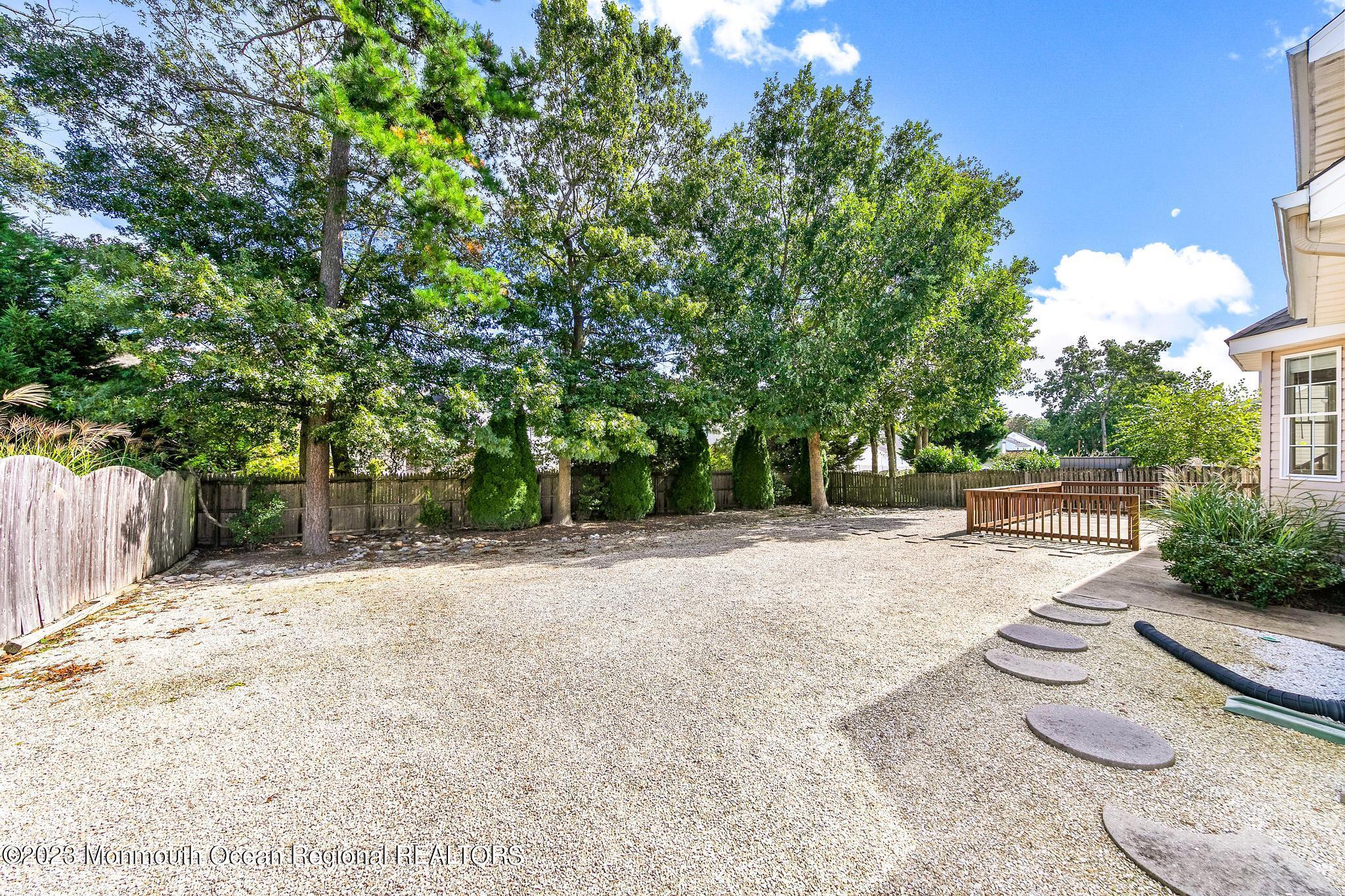 135 Barracuda Road Manahawkin, NJ 08050 - Photo 45 of 47 a view of a backyard with table and chairs potted plants and large tree