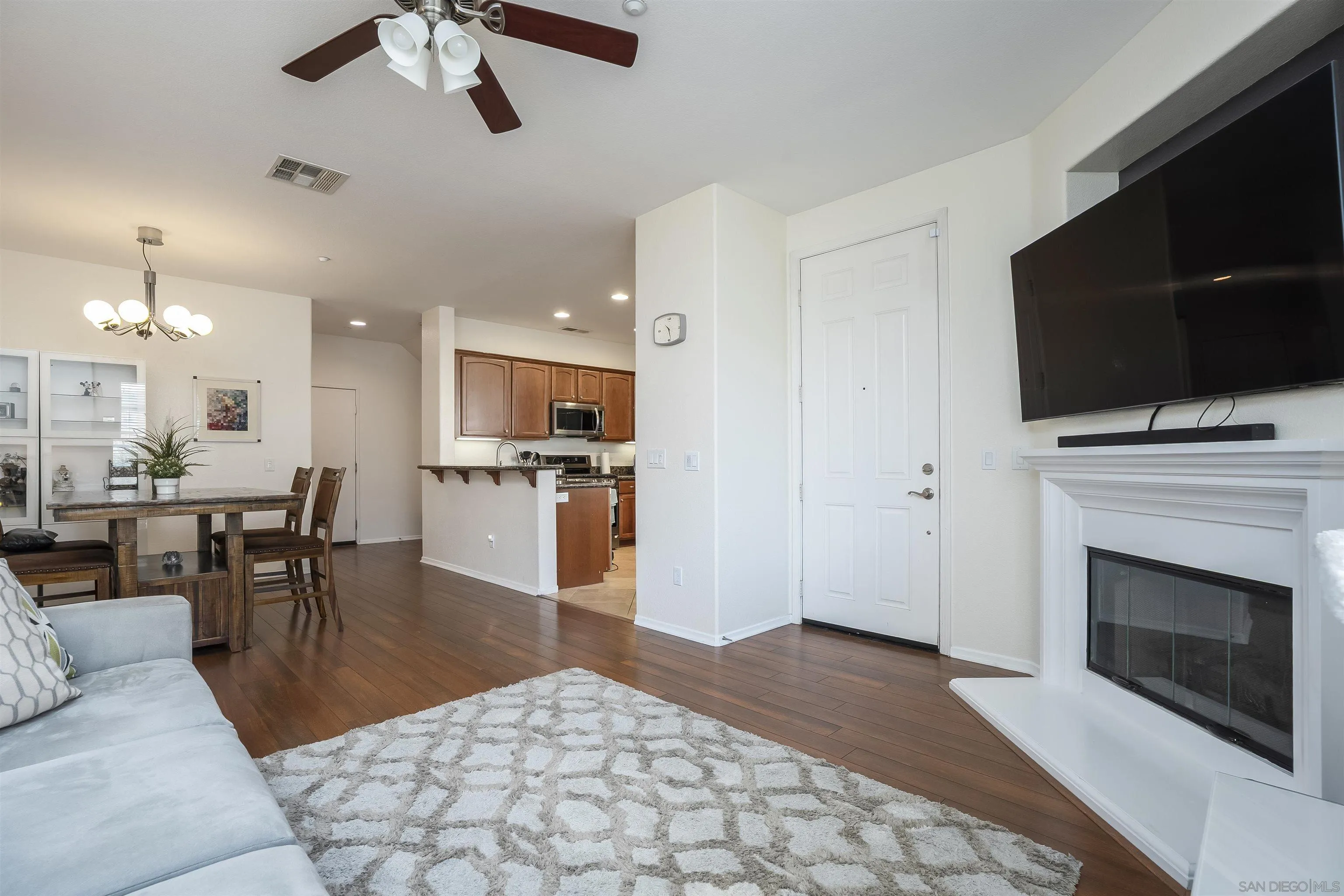 289 Reef Point Way, Unit 3 Oceanside, CA 92058 - Photo 5 of 23 a living room with stainless steel appliances kitchen island furniture and a flat screen tv