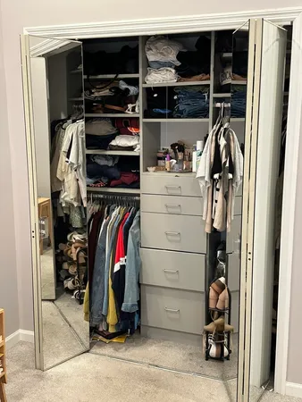 a view of walk in closet with clothes and shoes
