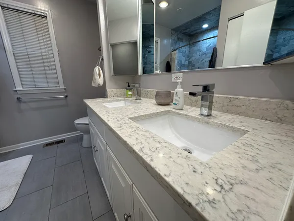a bathroom with a granite countertop sink a mirror and vanity
