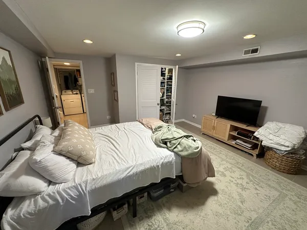a bedroom with bed and a flat screen tv