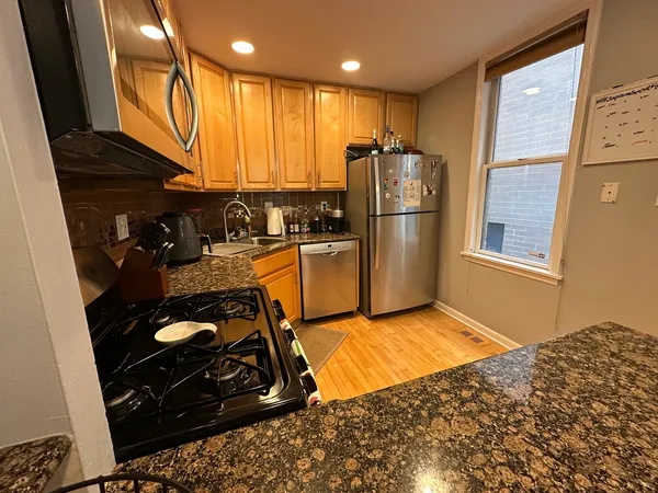 a kitchen with stainless steel appliances granite countertop a refrigerator stove and sink