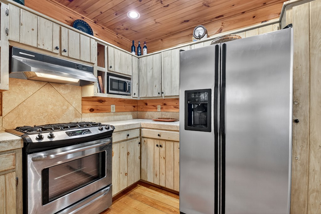 240 Lower Prince Mountain Road Cherry Log, GA 30522 - Photo 24 of 45 a kitchen with stainless steel appliances granite countertop a refrigerator a stove and a microwave oven with cabinets