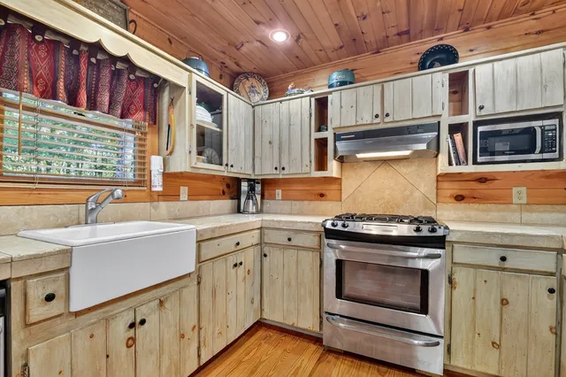 a kitchen with a stove sink and cabinets