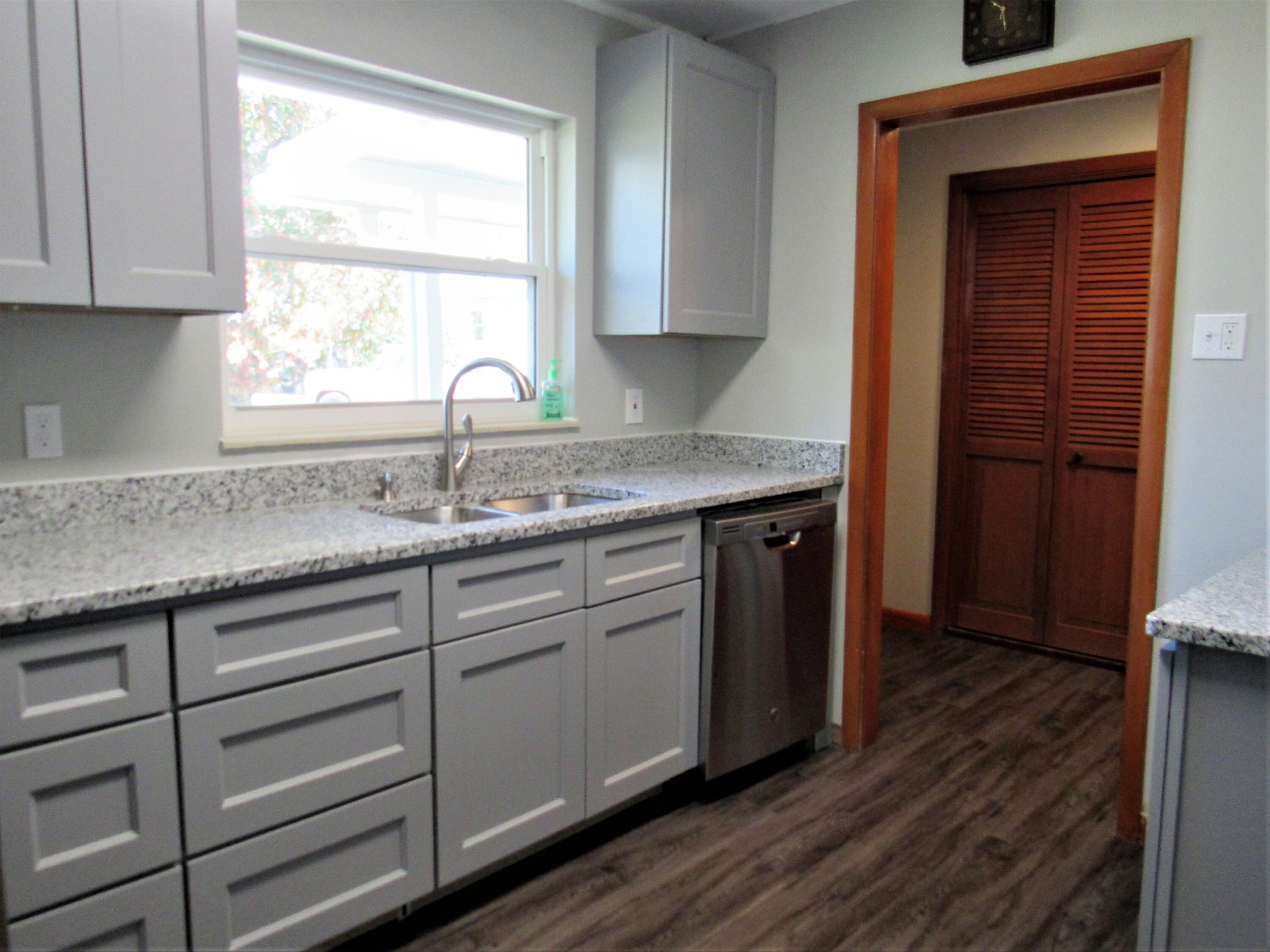 103 East Price Road Oak Ridge, TN 37830 - Photo 8 of 37 a kitchen with granite countertop wooden cabinets a sink and dishwasher with wooden floor
