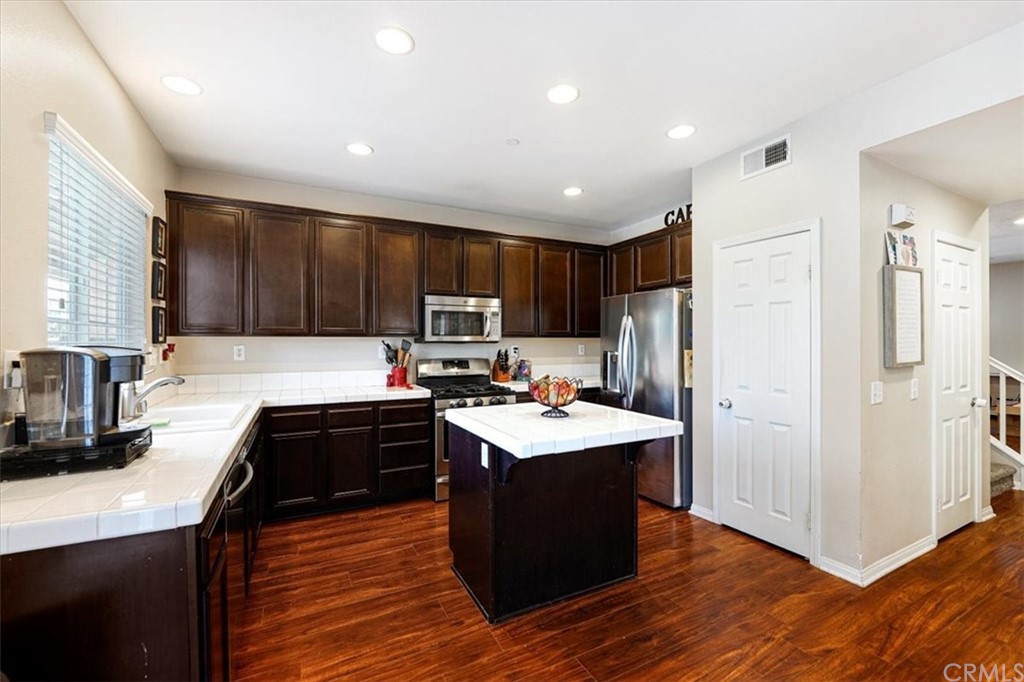 1777 Carrie Way Riverside, CA 92501 - Photo 6 of 35 a kitchen with wooden cabinets and stainless steel appliances