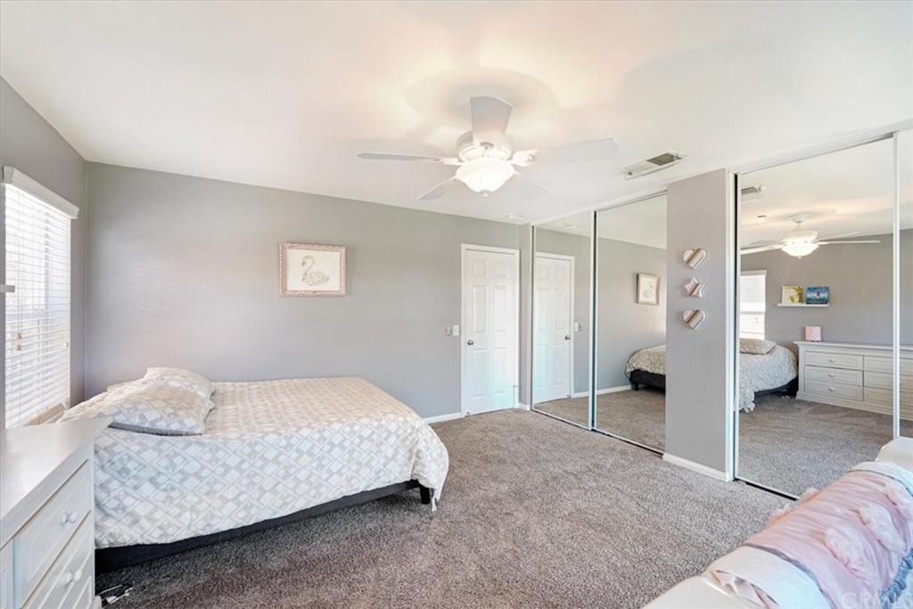 1777 Carrie Way Riverside, CA 92501 - Photo 9 of 35 a spacious bedroom with a bed and a chandelier