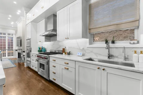 a kitchen with stainless steel appliances granite countertop white cabinets sink and stove
