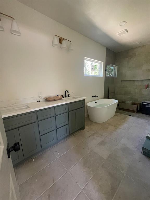 608 Ritchey Street Gainesville, TX 76240 - Photo 8 of 10 a spacious bathroom with a double vanity sink toilet and a mirror