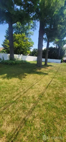 a view of a yard with a house and large trees