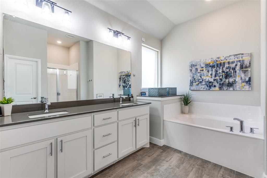 1829 Bellatrix Drive Haslet, TX 76052 - Photo 16 of 25 a bathroom with double vanity sinks a large mirror and a bathtub